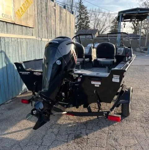 Slide: The Image of 2025 Tracker Pro Guide V-16 WT boat with outboard motor, parked outdoors. - 3