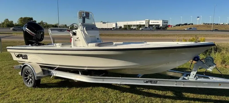 Slide: The Image of 2025 Mako 18 LTS boat on trailer, parked on grass near highway. - 4