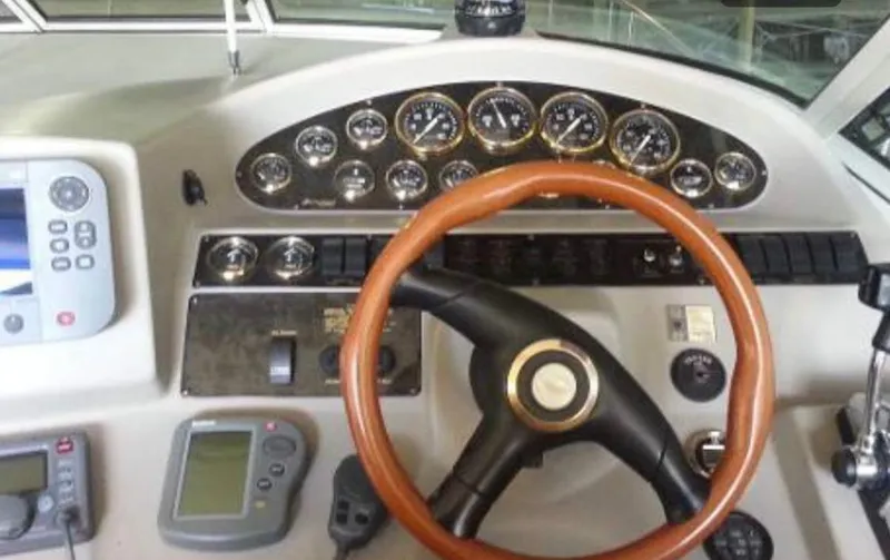 Slide: The Image of 2001 Cruisers Yachts 3075 Express dashboard with gauges, steering wheel, and navigation equipment. - 10