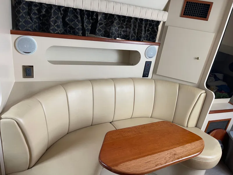 Slide: The Image of Interior of 2001 Cruisers Yachts 3075 Express with leather seating and wooden table. - 14