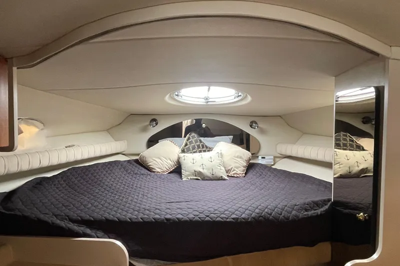 Slide: The Image of Interior cabin of 2001 Cruisers Yachts 3075 Express with cozy bedding and porthole. - 16