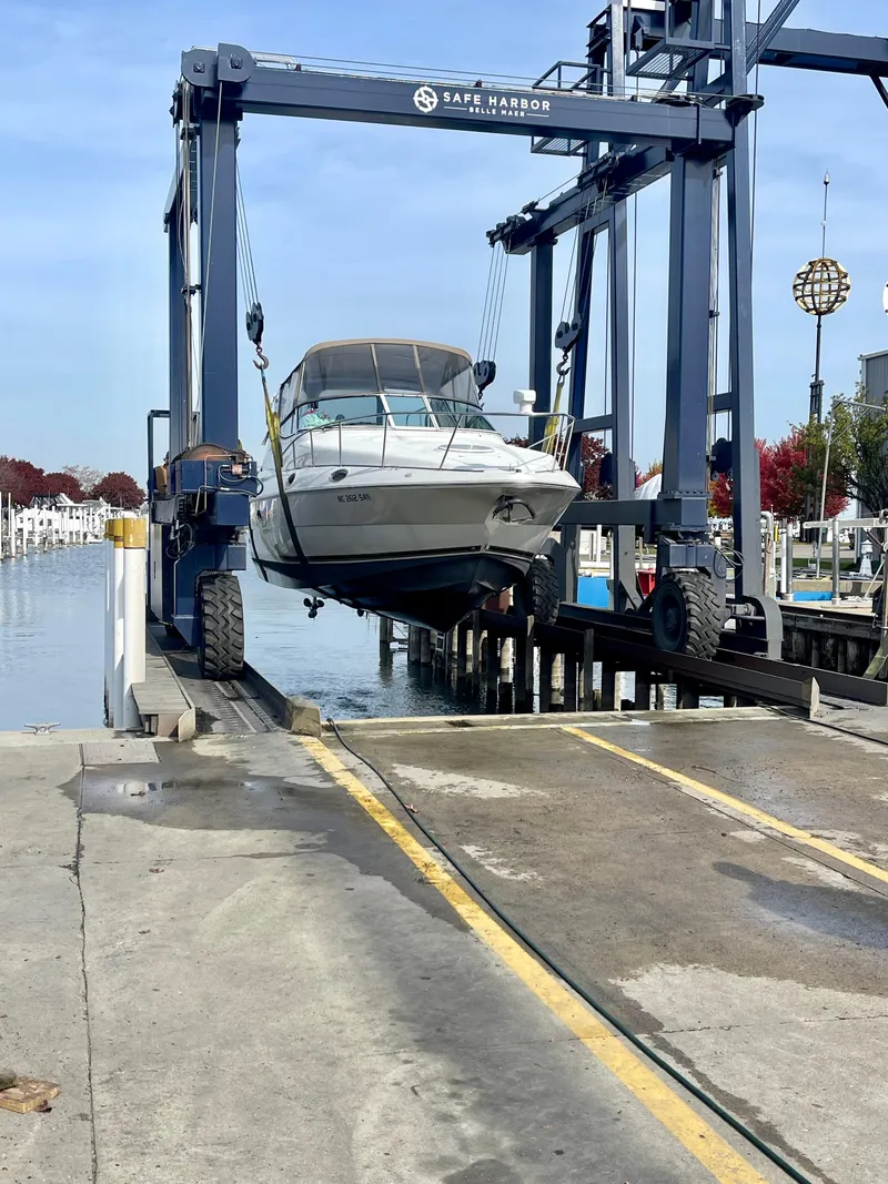 Slide: The Image of 2001 Cruisers Yachts 3075 Express being lifted at marina dock. - 3