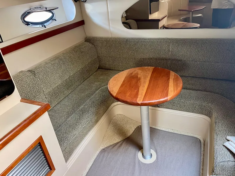 Slide: The Image of 2001 Cruisers Yachts 3075 Express cabin with cozy seating and wooden table. - 20