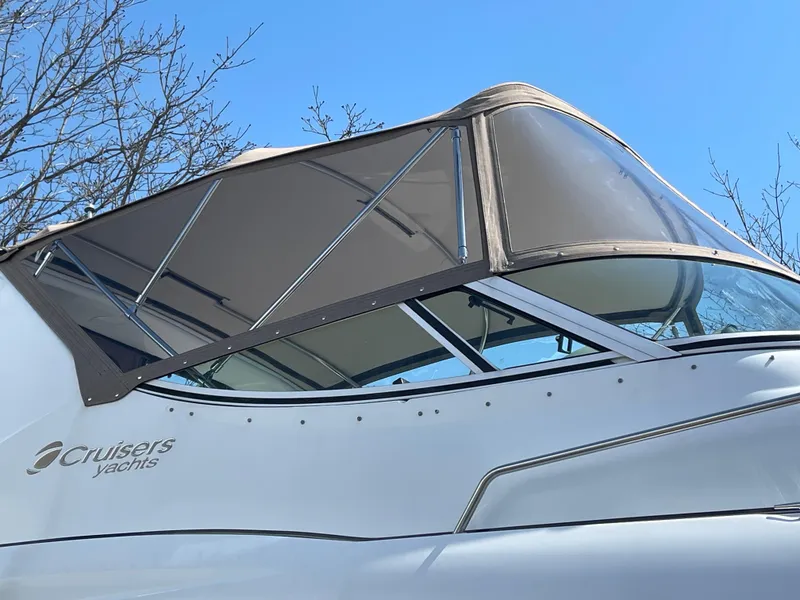 Slide: The Image of 2001 Cruisers Yachts 3075 Express boat with canopy against blue sky. - 5