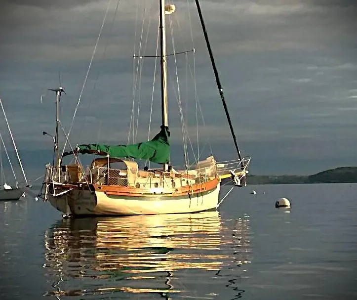 Slide: The Image of 1985 Bristol Channel Cutter sailboat on calm water at sunset. - 1