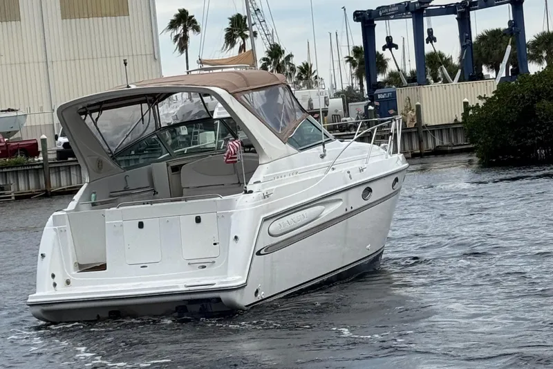 Slide: The Image of 2000 Maxum 3000 SCR boat on water near marina with palm trees. - 6