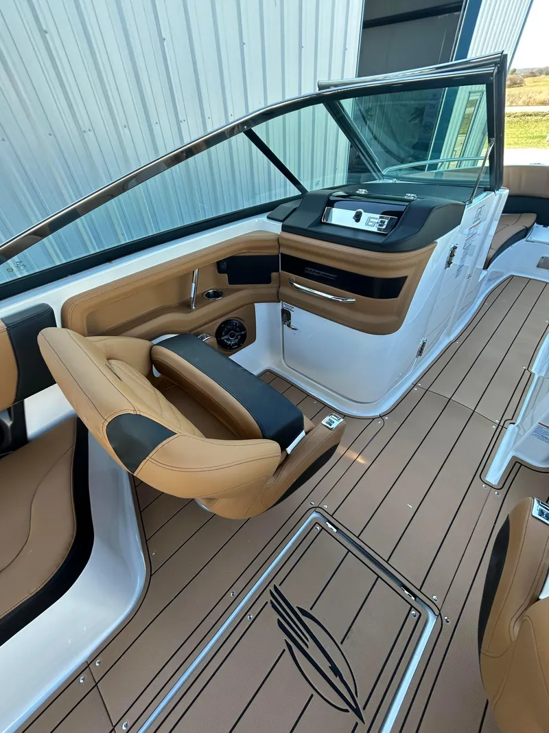 Slide: The Image of 2025 Chaparral 307 SSX boat interior with tan seating and modern dashboard. - 10
