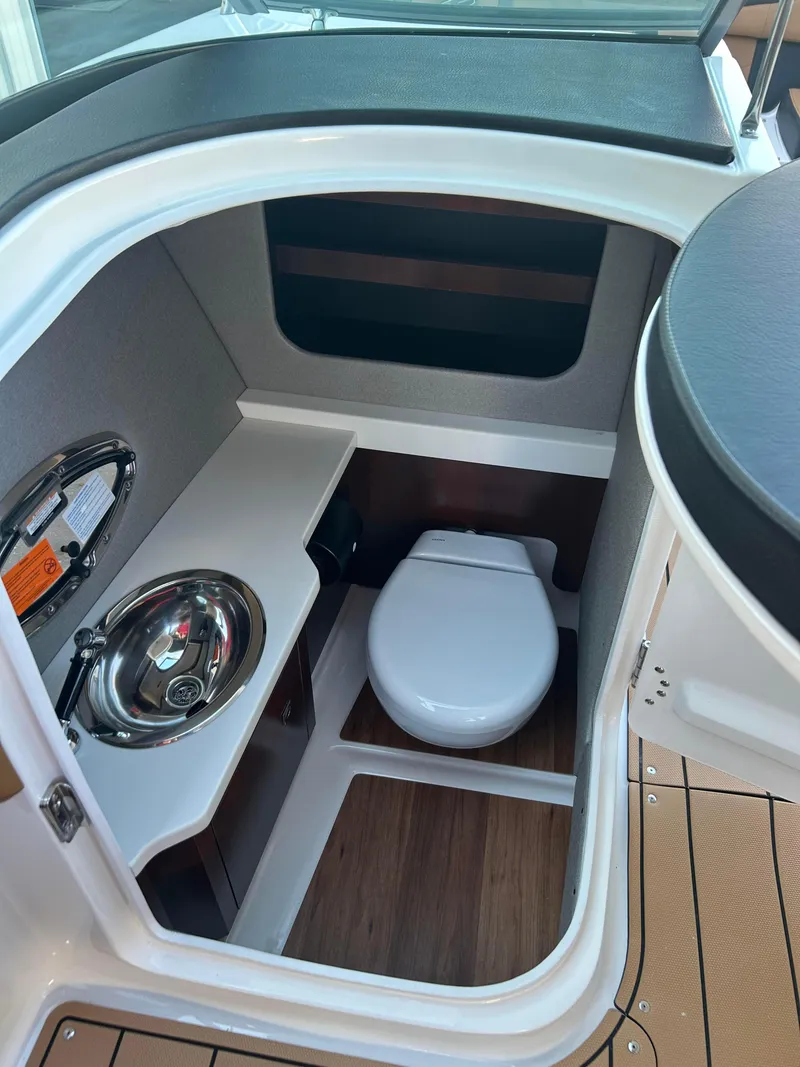 Slide: The Image of 2025 Chaparral 307 SSX boat interior with compact bathroom and sink. - 11
