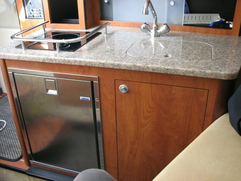 Slide: The Image of Compact kitchen area in 2013 Monterey 280 Sport Yacht with sink, stove, and mini-fridge. - 14