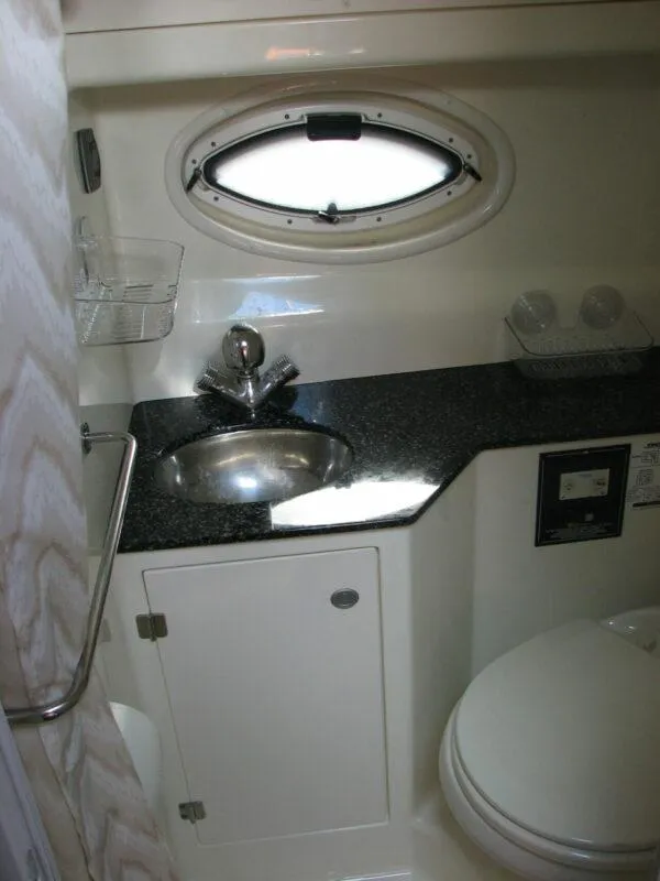 Slide: The Image of 2013 Monterey 280 Sport Yacht bathroom with sink, toilet, and porthole window. - 8