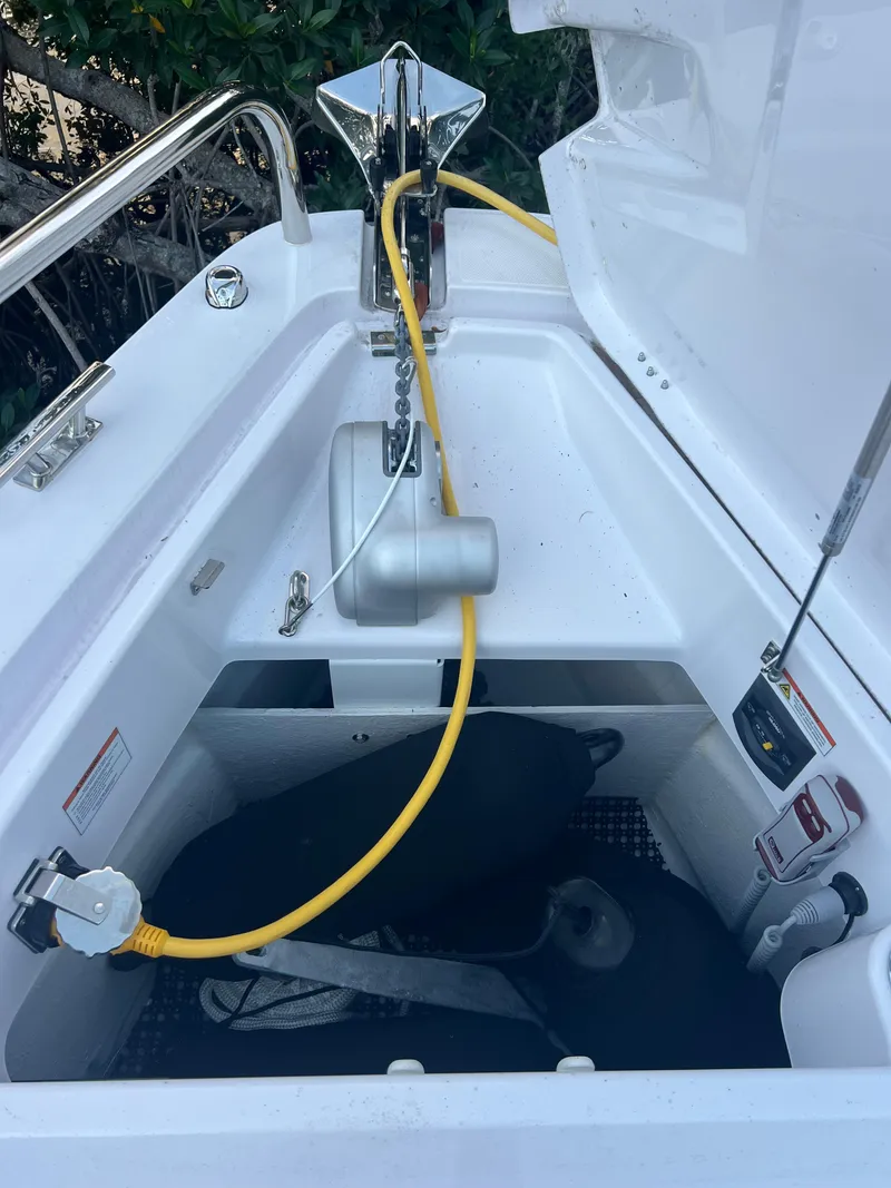 Slide: The Image of 2024 Axopar Sun Top anchor compartment with yellow cable and storage. - 23