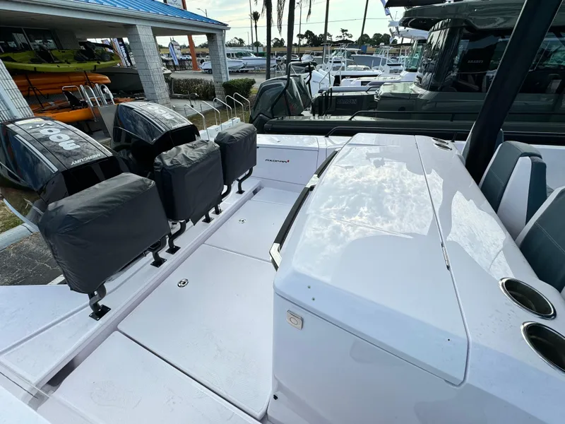 Slide: The Image of 2024 Axopar Sun Top boat with covered Mercury engines at a marina. - 6