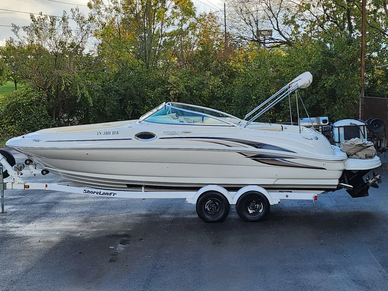 Slide: The Image of 2002 Sea Ray 240 Sundeck boat on trailer, parked outdoors. - 0