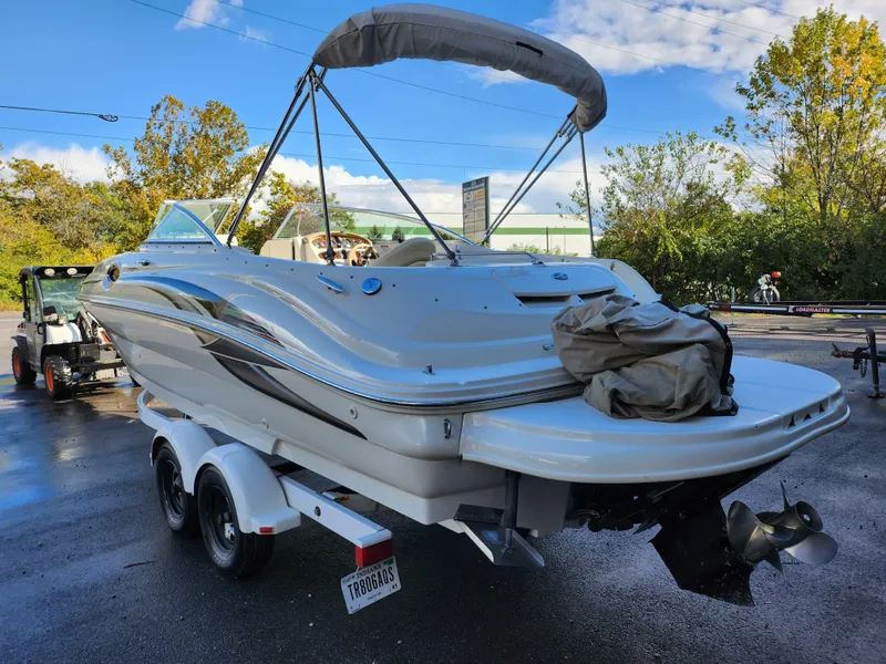 Slide: The Image of 2002 Sea Ray 240 Sundeck boat on trailer, parked outdoors. - 1