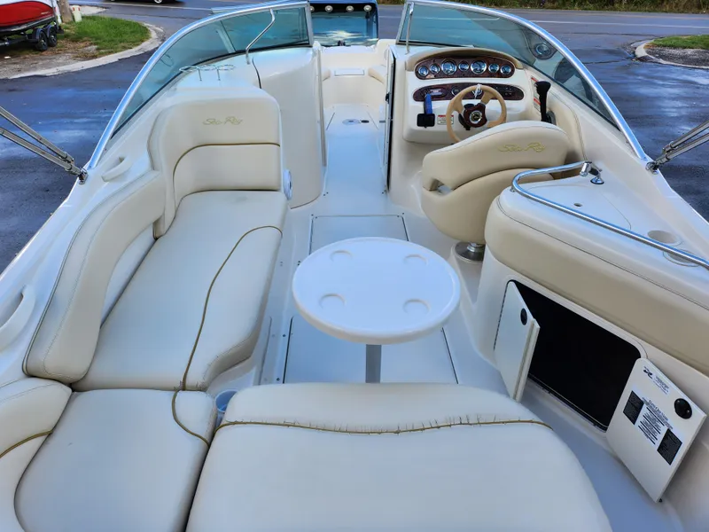 Slide: The Image of 2002 Sea Ray 240 Sundeck boat interior with cream leather seating and round table. - 10