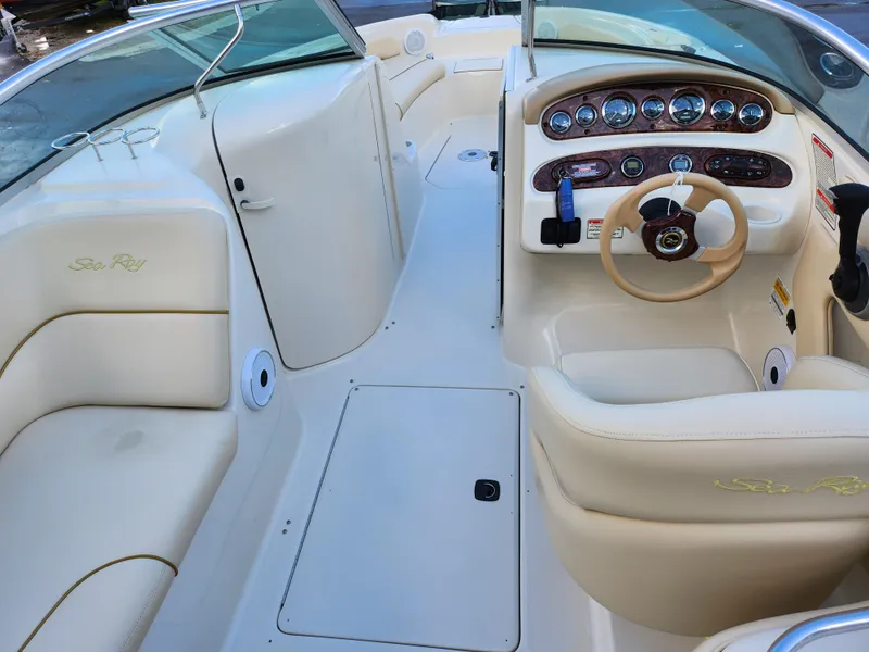 Slide: The Image of Interior of 2002 Sea Ray 240 Sundeck boat with beige seating and dashboard. - 13