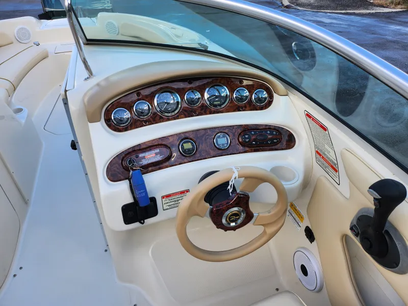 Slide: The Image of 2002 Sea Ray 240 Sundeck dashboard with gauges and steering wheel. - 14