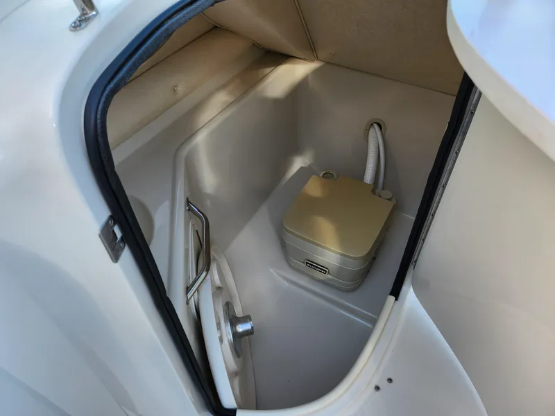 Slide: The Image of 2002 Sea Ray 240 Sundeck interior storage compartment with portable toilet. - 16