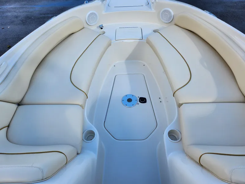 Slide: The Image of 2002 Sea Ray 240 Sundeck interior with beige seating and cup holders. - 18