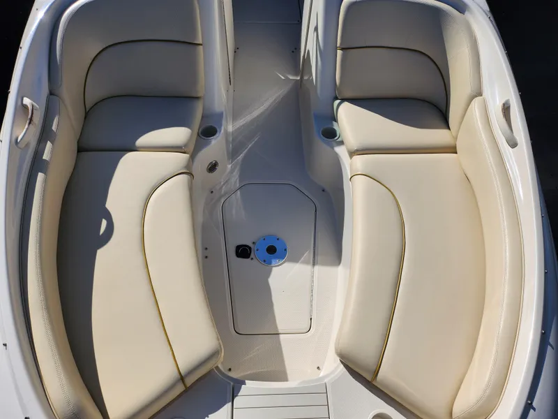 Slide: The Image of 2002 Sea Ray 240 Sundeck interior with beige seating and cup holders. - 20