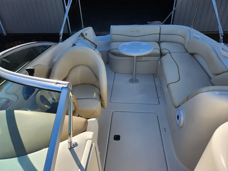 Slide: The Image of 2002 Sea Ray 240 Sundeck interior with beige seating and round table. - 22