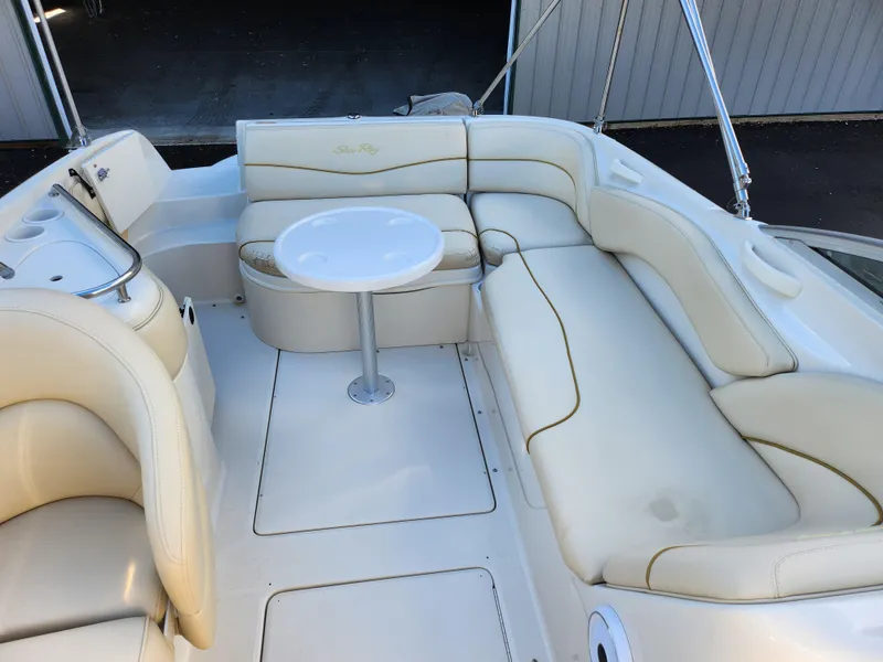 Slide: The Image of 2002 Sea Ray 240 Sundeck interior with cream seating and round table. - 23
