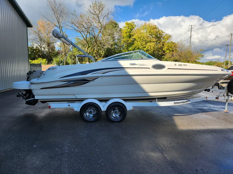 Slide: The Image of 2002 Sea Ray 240 Sundeck boat on trailer, parked outdoors. - 4