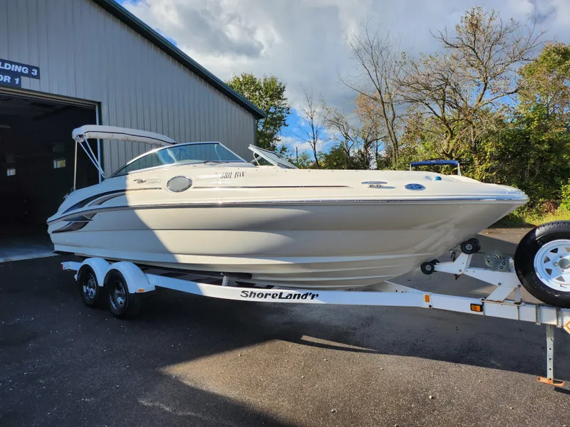 Slide: The Image of 2002 Sea Ray 240 Sundeck boat on ShoreLand'r trailer outside a building. - 5