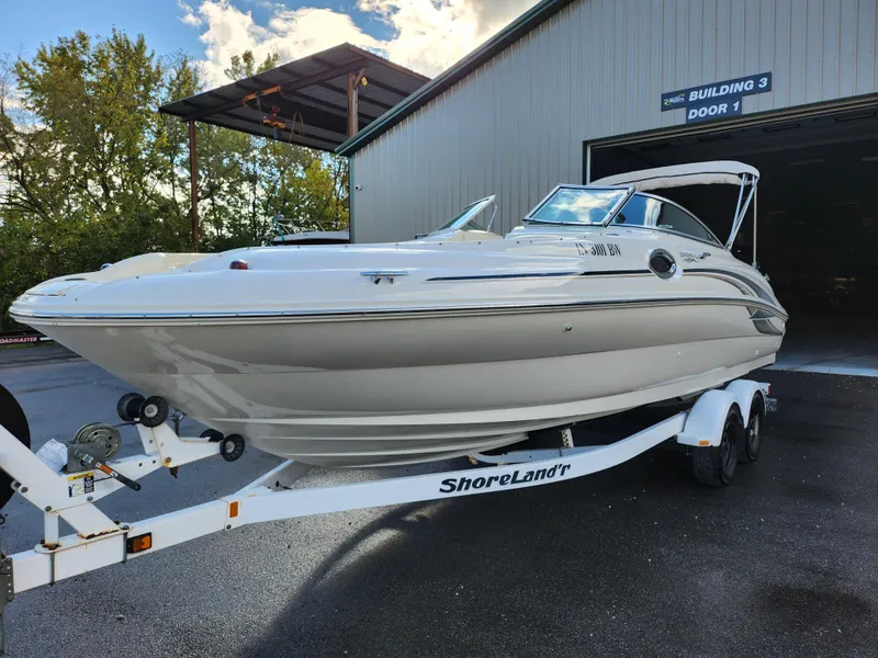 Slide: The Image of 2002 Sea Ray 240 Sundeck boat on ShoreLand'r trailer outside building. - 8