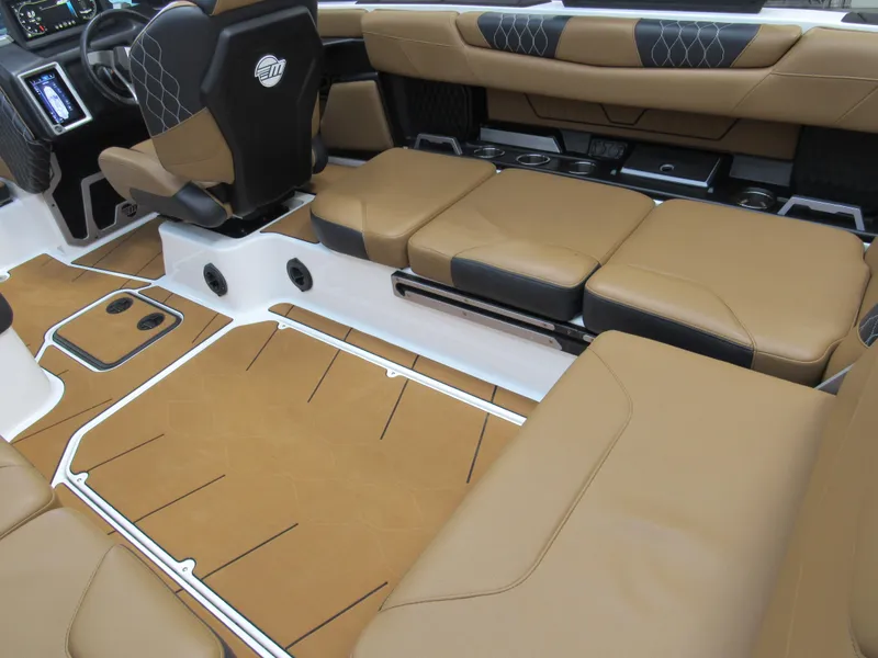 Slide: The Image of 2022 Malibu M220 boat interior with tan leather seating and modern dashboard. - 10