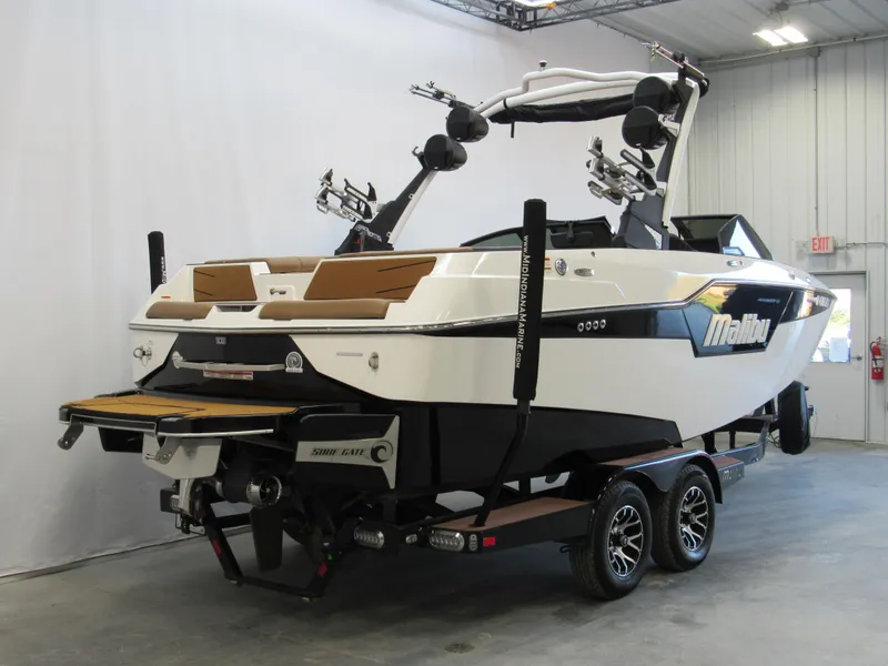 Slide: The Image of 2022 Malibu M220 boat on trailer in indoor showroom. - 3