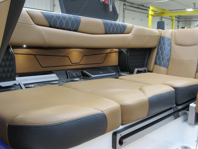 Slide: The Image of 2022 Malibu M220 boat interior with luxurious tan and black seating. - 9