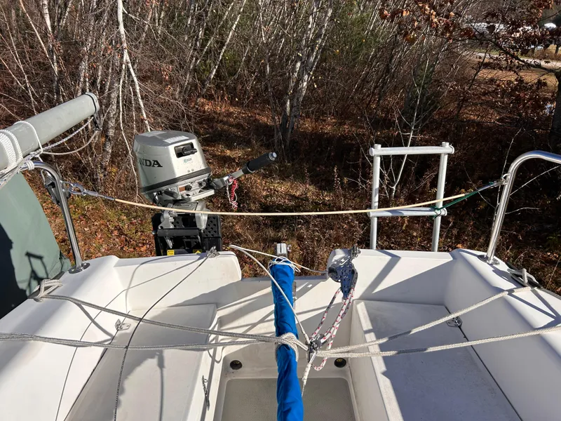 Slide: The Image of Catalina 22 Capri sailboat with Honda outboard motor, docked in a wooded area. - 12