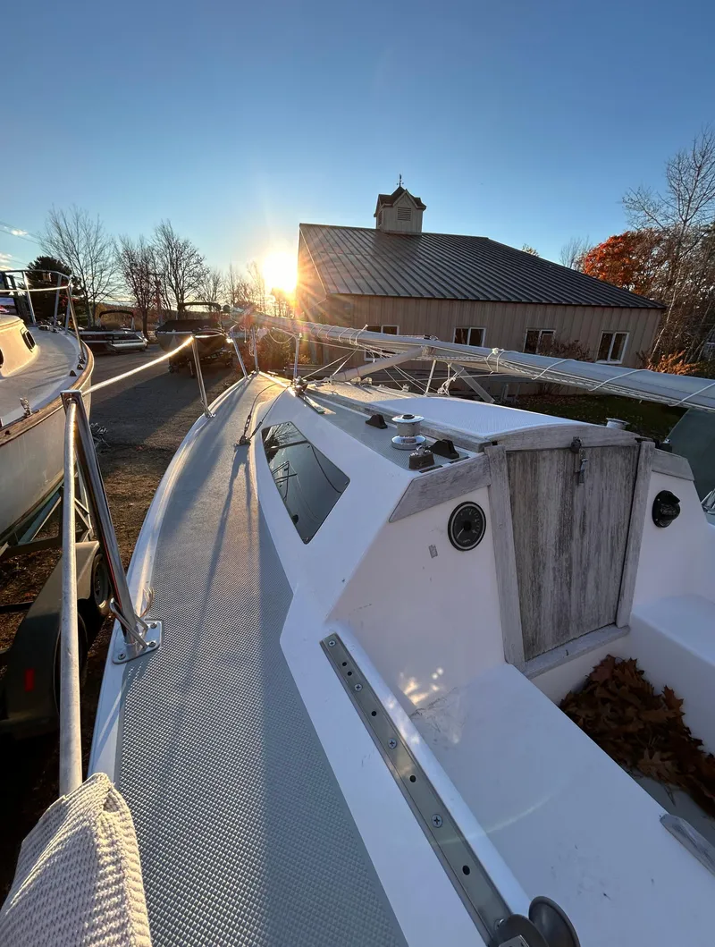 Slide: The Image of 1987 Catalina 22 Capri sailboat docked at sunset near a barn. - 17