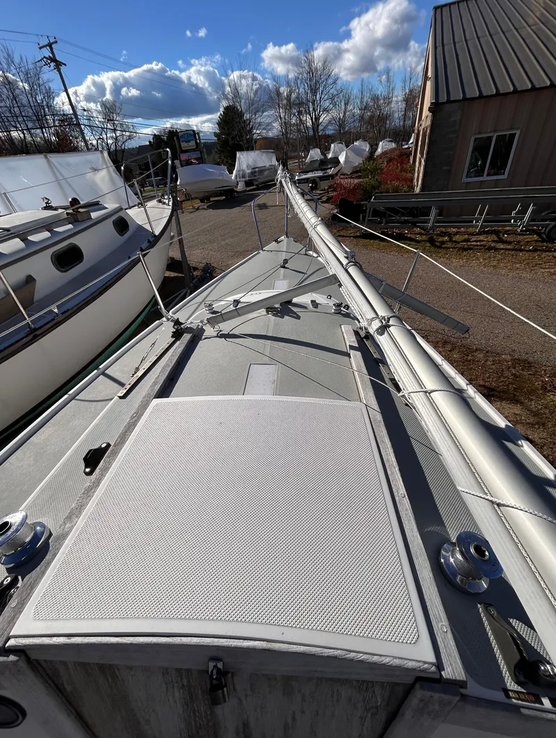 Slide: The Image of 1987 Catalina 22 Capri sailboat deck with mast, docked in a marina under blue skies. - 19