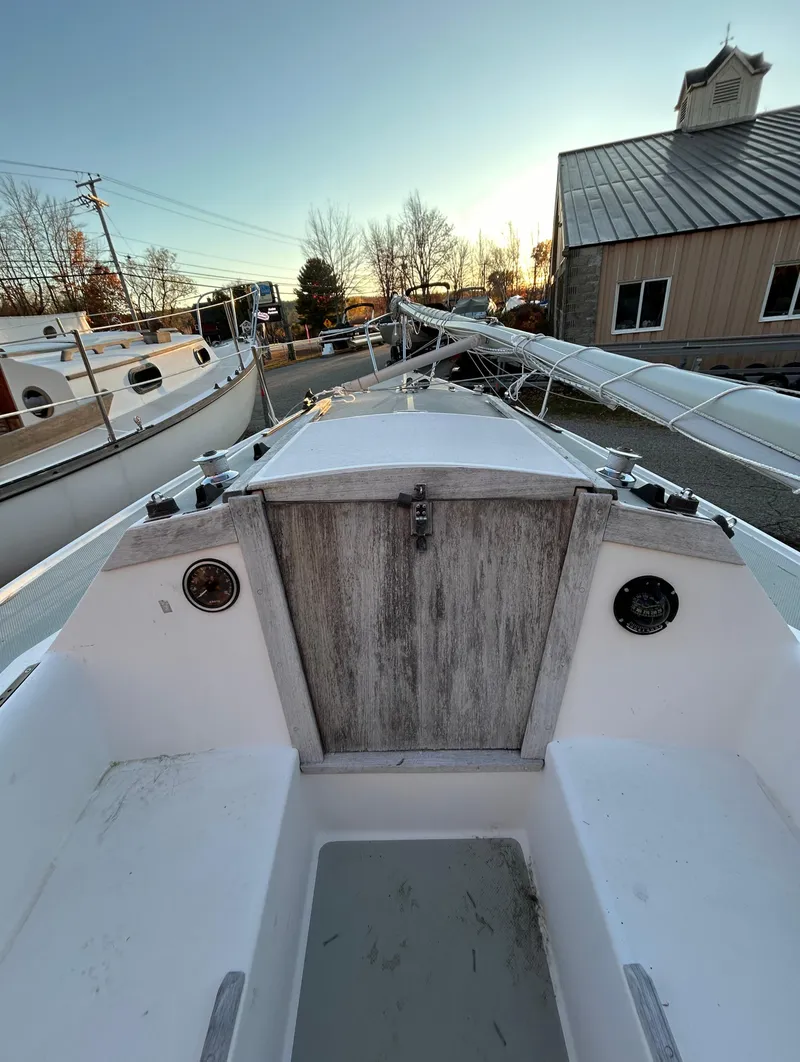 Slide: The Image of 1987 Catalina 22 Capri sailboat cockpit with wooden hatch, docked in a marina. - 25