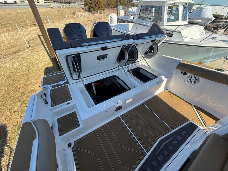 Slide: The Image of 2025 Monterey Elite 30 OB boat with open storage compartments and dual engines. - 10