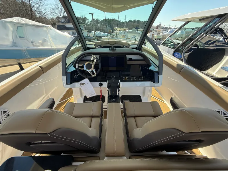 Slide: The Image of Interior view of 2025 Monterey Elite 30 OB boat with modern dashboard and seating. - 14