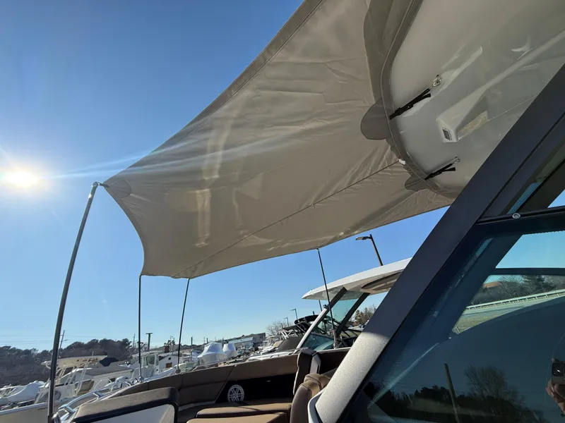 Slide: The Image of 2025 Monterey Elite 30 OB boat with sunshade, docked under clear blue sky. - 19