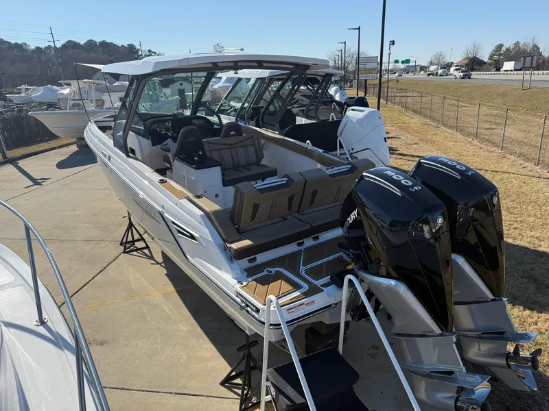 Slide: The Image of 2025 Monterey Elite 30 OB boat with dual outboard engines, docked outdoors. - 2