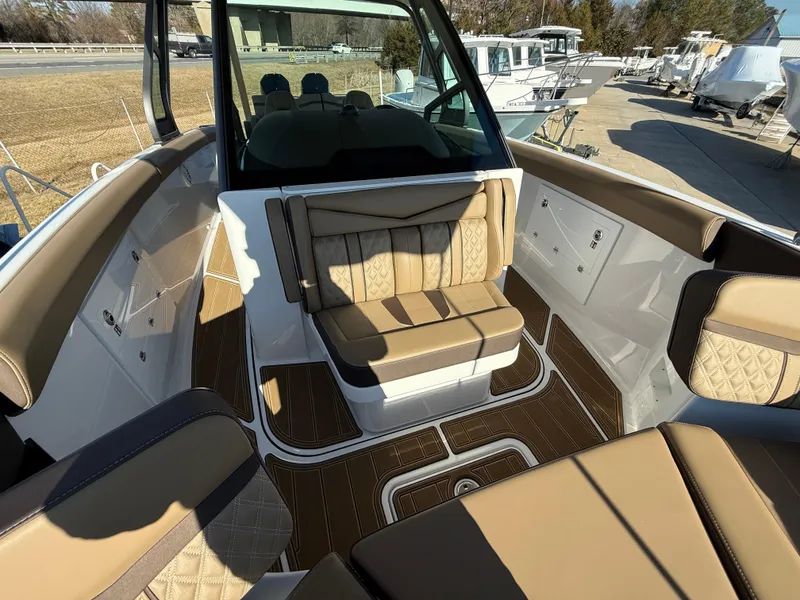 Slide: The Image of 2025 Monterey Elite 30 OB boat interior with tan seating and wood accents. - 24