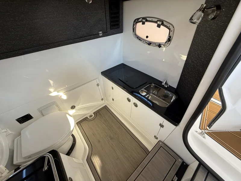 Slide: The Image of 2025 Monterey Elite 30 OB boat interior with sink, toilet, and window. - 27