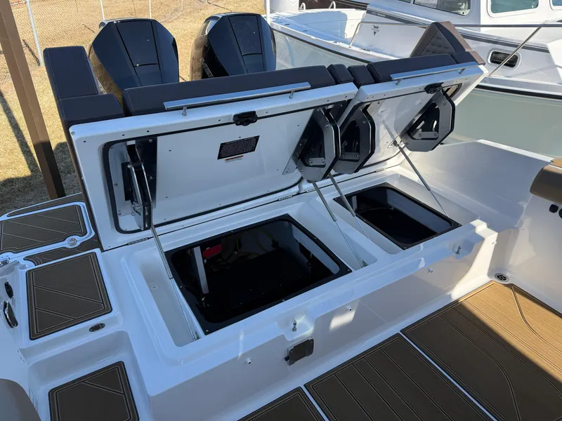 Slide: The Image of 2025 Monterey Elite 30 OB boat with open storage compartments and dual engines. - 9