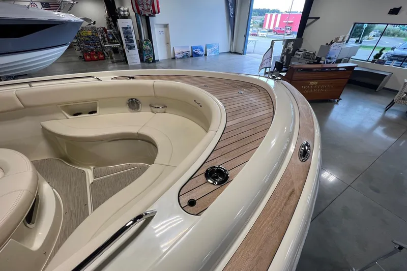 Slide: The Image of 2025 Chris-Craft Catalina 30 boat interior with elegant seating and wood accents in showroom. - 16