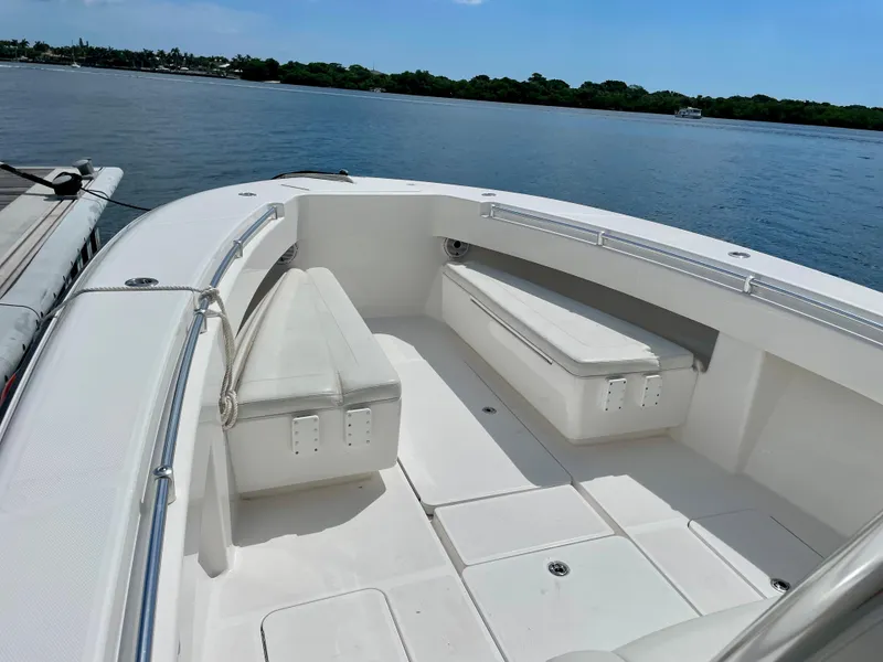 Slide: The Image of 2020 Invincible 33 Open Fisherman boat interior with seating, docked by calm waters. - 11