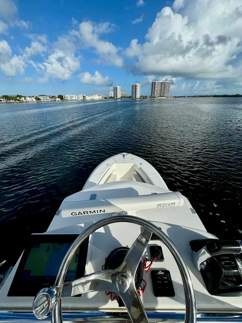 Slide: The Image of 2020 Invincible 33 Open Fisherman boat on calm water with city skyline. - 17