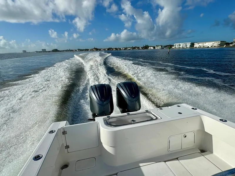 Slide: The Image of 2020 Invincible 33 Open Fisherman boat cruising on open water, twin engines visible. - 24