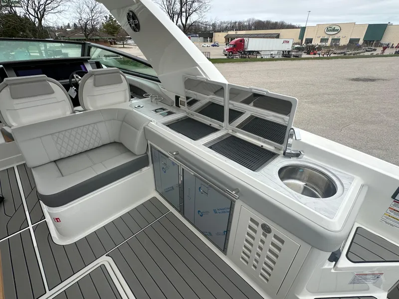 Slide: The Image of 2025 Sea Ray SLX 400 OB boat interior with seating, kitchenette, and sink. - 13