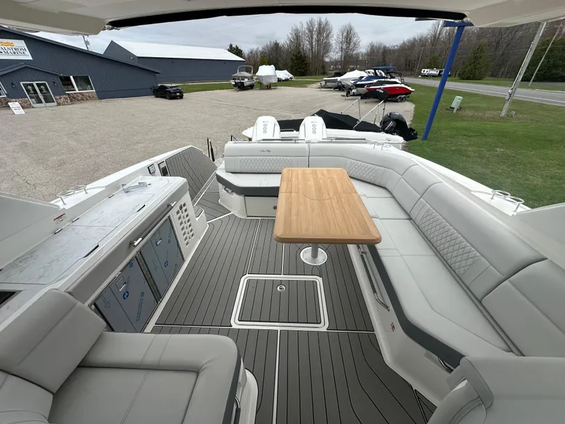 Slide: The Image of 2025 Sea Ray SLX 400 OB boat interior with spacious seating and wooden table. - 15