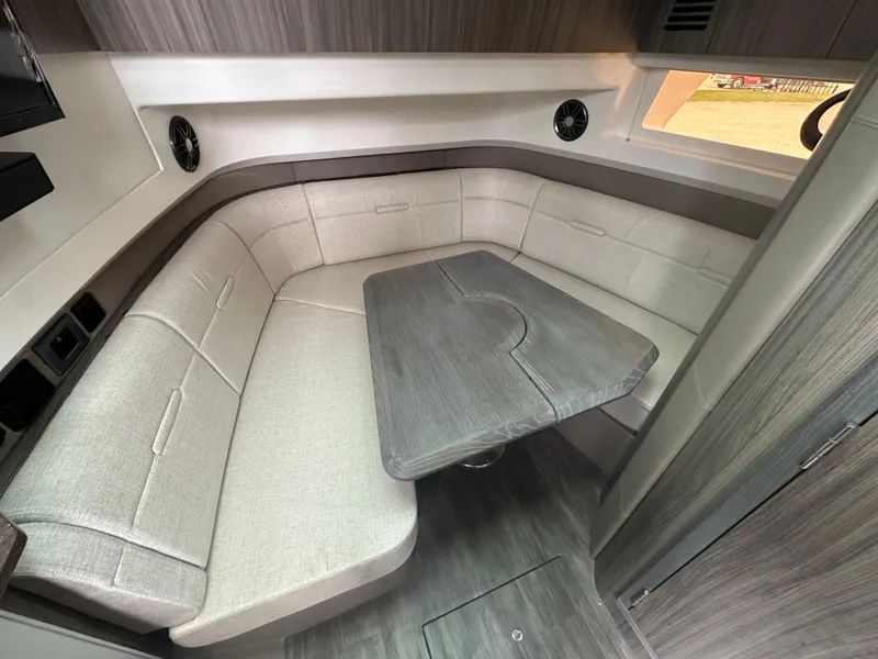 Slide: The Image of 2025 Sea Ray SLX 400 OB cabin interior with plush seating and a central table. - 18